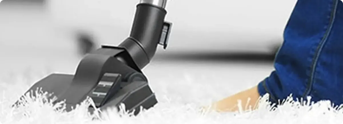 Close-up of a professional vacuuming a white carpet in Renton.